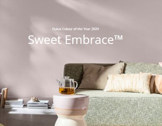 Image of blush pink wall with sofa and cushions and side table with pot of tea on it. The words Sweet Embrace are in the foreground.